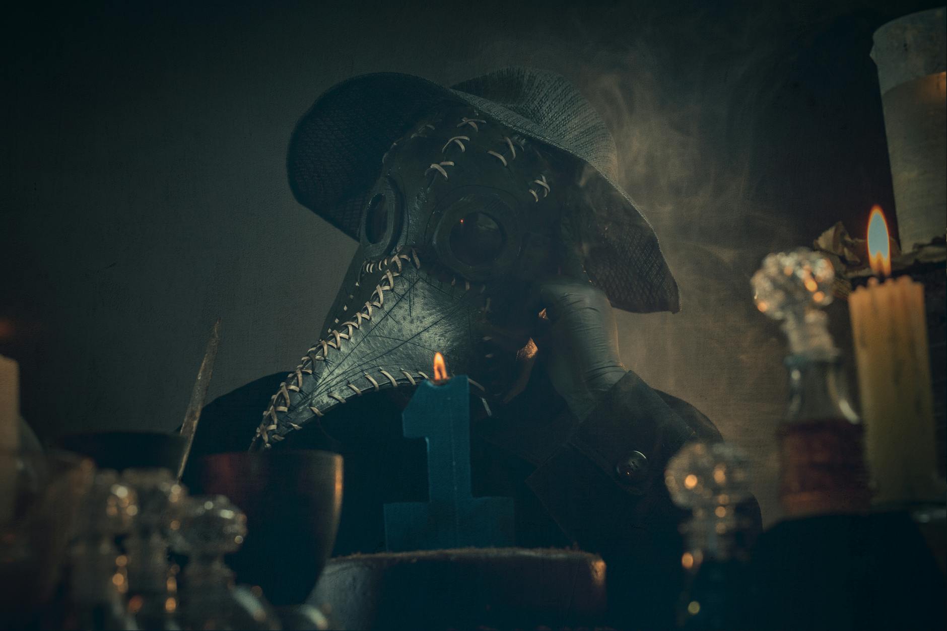 Lekarz w masce przeciwmorowej wśród dymu i światła świec