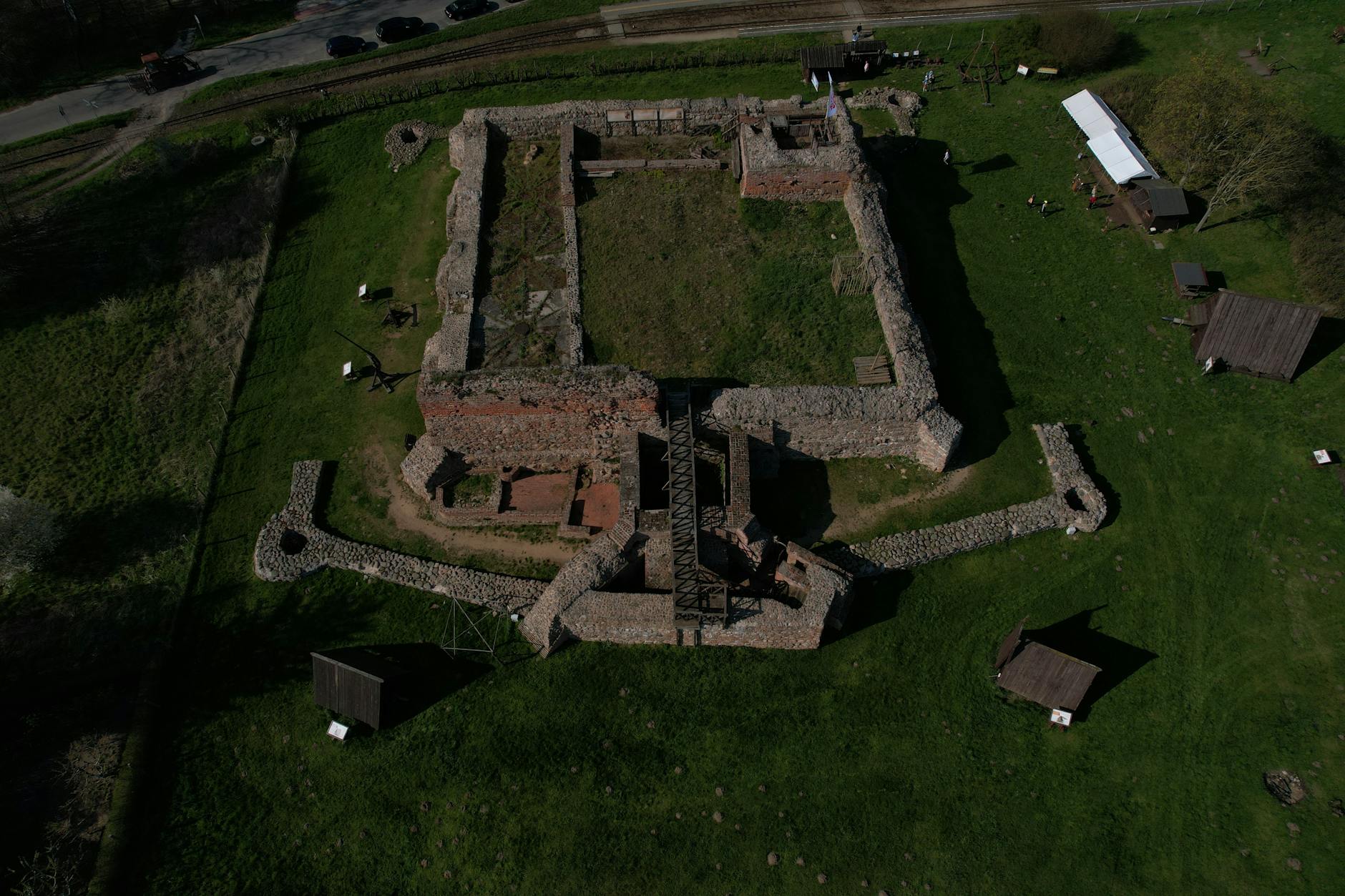 Ruiny średniowiecznego kamiennego zamku na polskiej wsi z lotu ptaka
