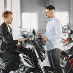Sprzedawca i klient rozmawiają o motocyklu w salonie motocyklowym