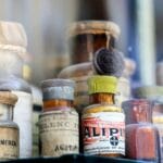 Zabytkowe butelki farmaceutyczne w antycznej szklanej gablocie