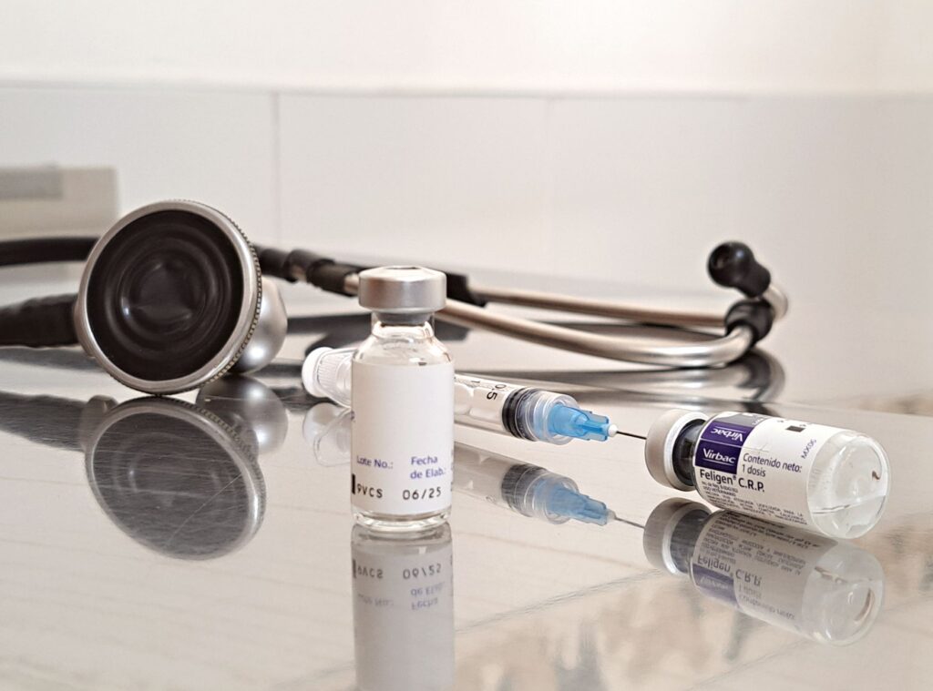 Szczepionki, strzykawka i stetoskop na klinicznym blacie